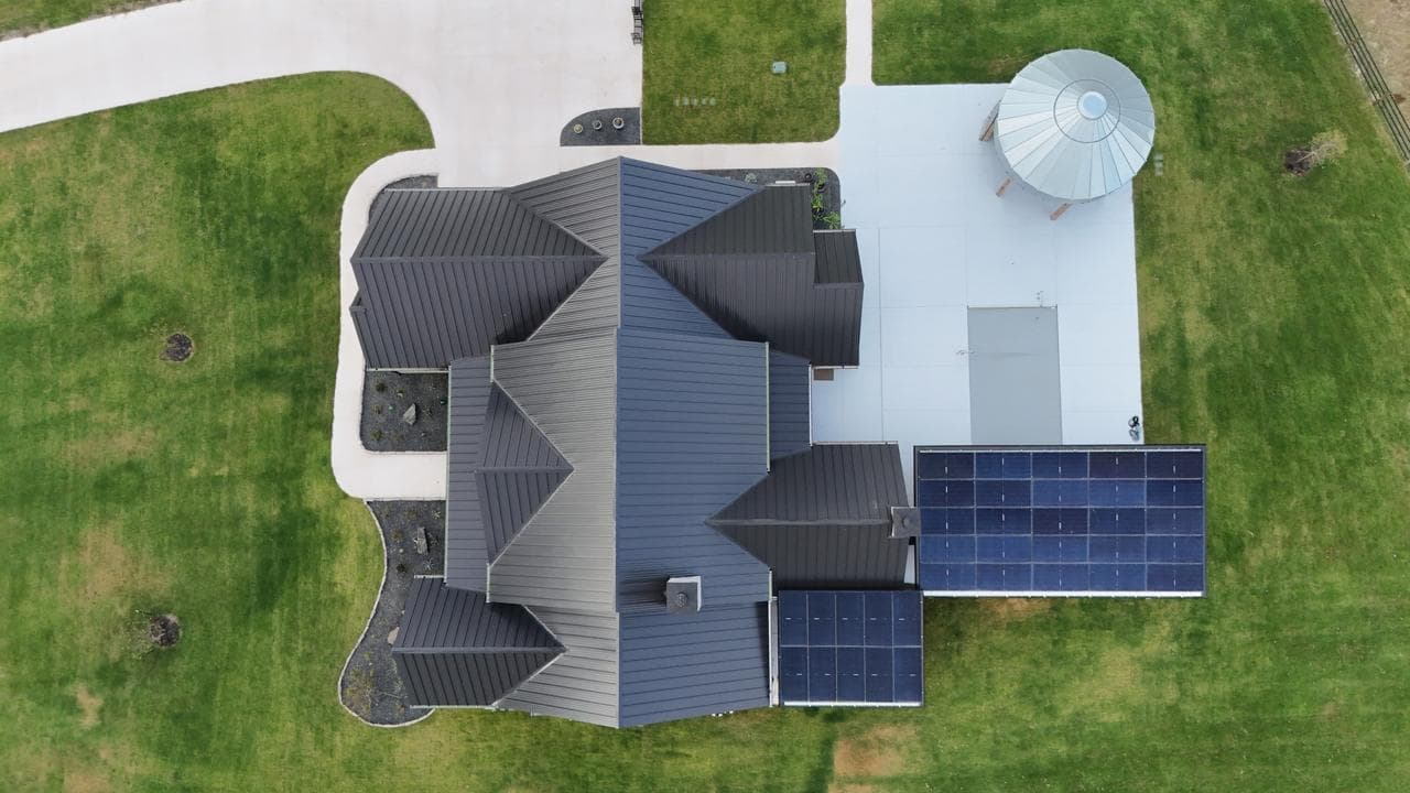 Aerial drone view of solar array on a Texas ranch estate with metal roof